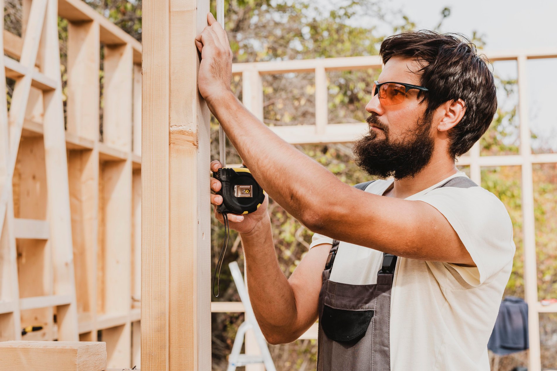 Contractor measuring wood framing